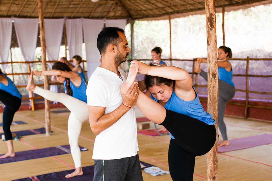 Yogacharya Lalit guiding student with alignment