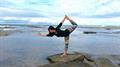 dancer pose orginal on rock at sujny coast